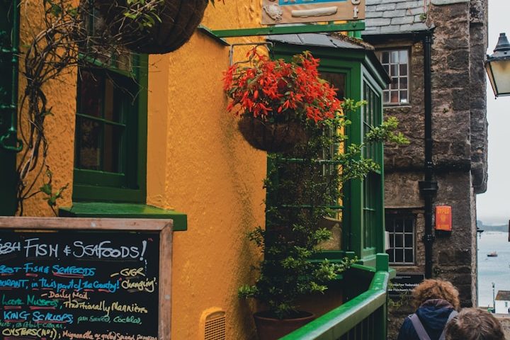 a photo of a pub in Newport with flowers and a sign board